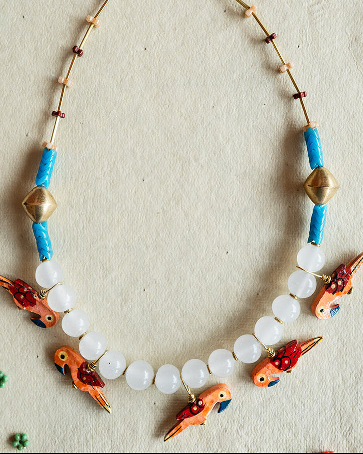 Necklace with fish-shaped beads on a textured white background