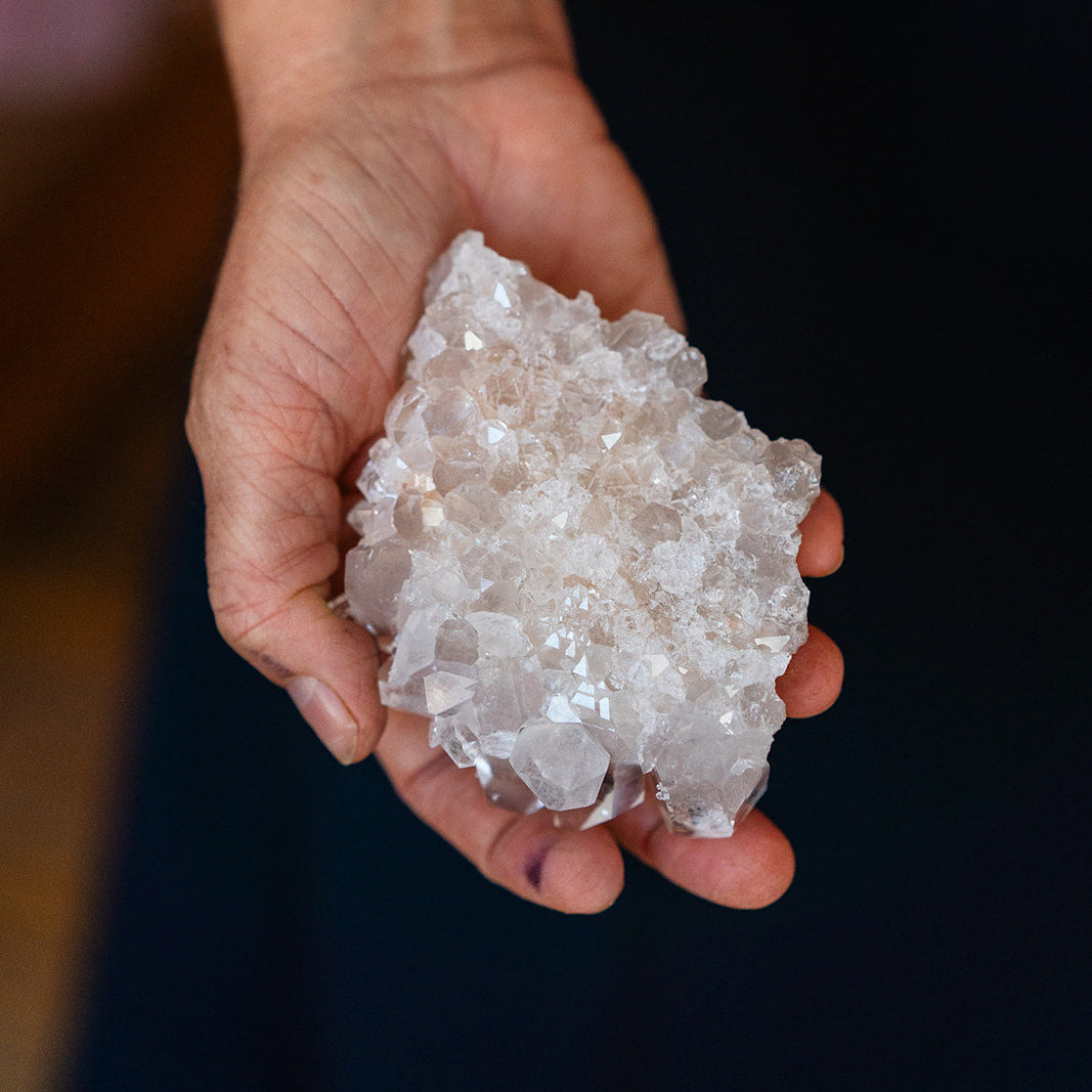 Brandy holding a crystal rock against a dark background