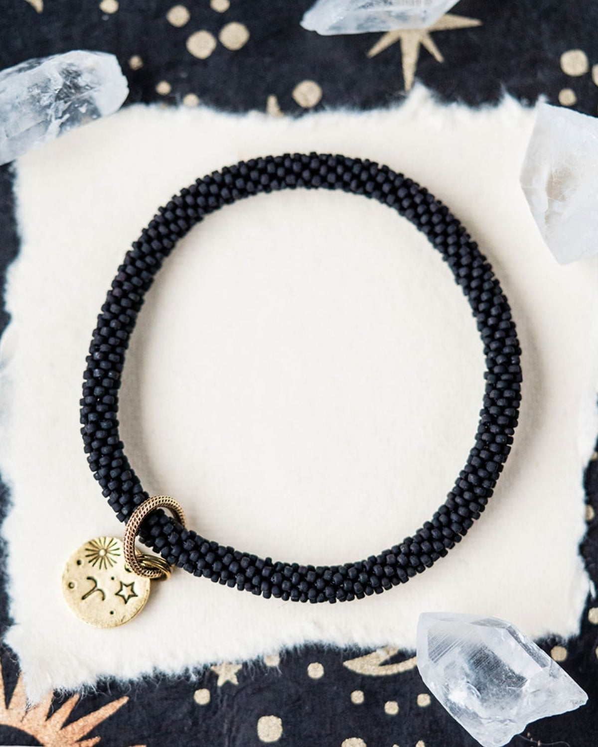 Black beaded bracelet with gold Aries zodiac pendant styled with clear crystals and stars