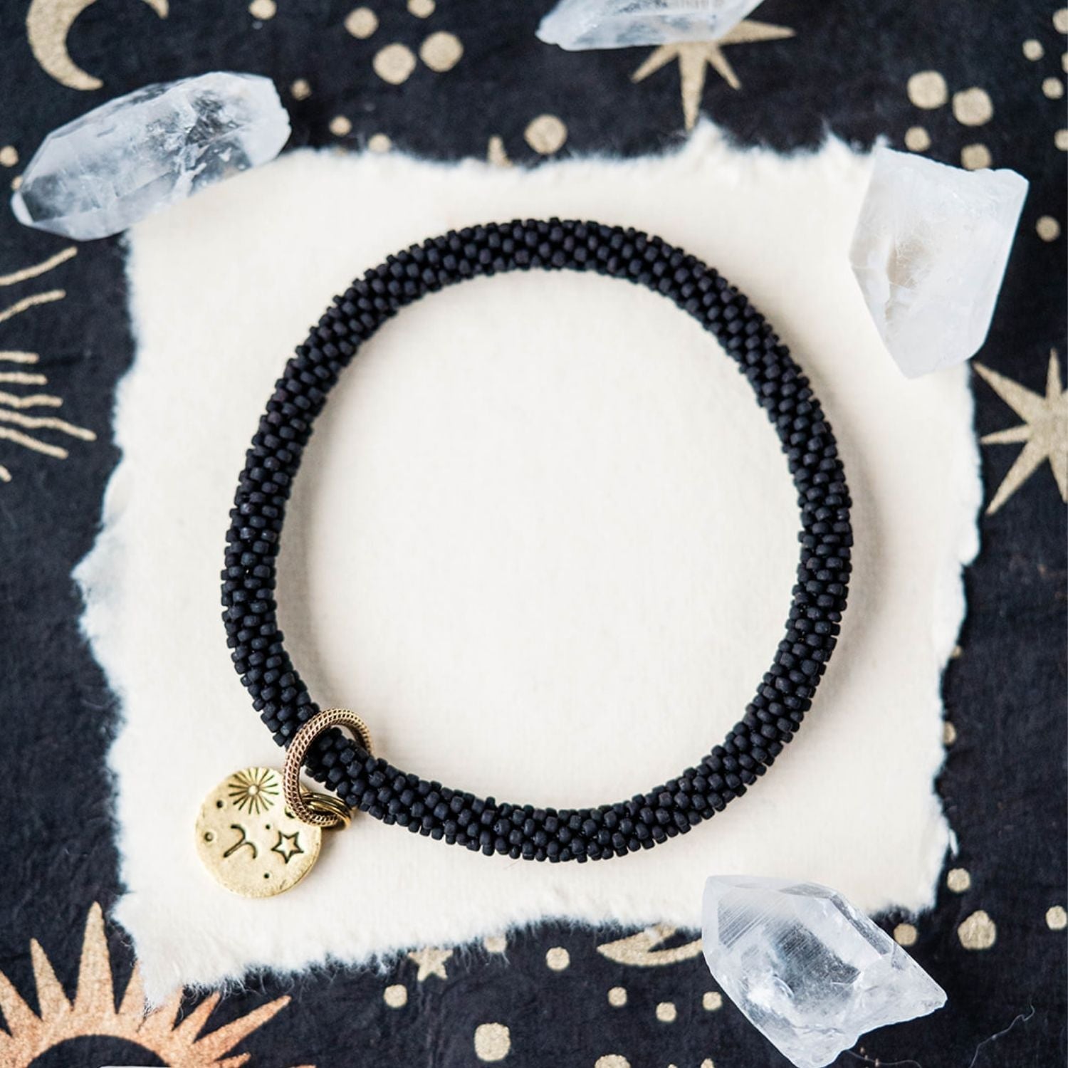 Black beaded bracelet with gold Aries zodiac pendant styled with clear crystals and stars