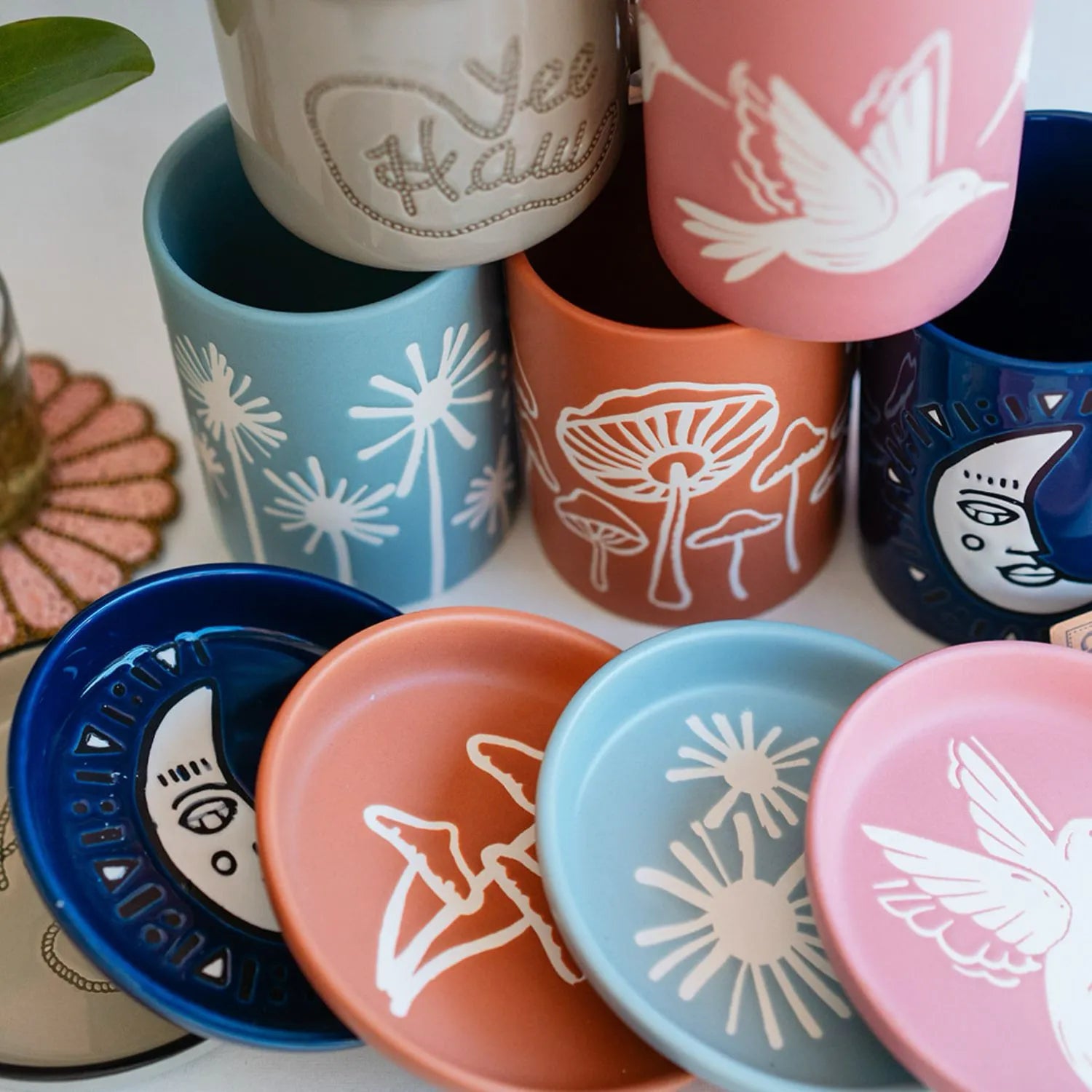 Colorful handpainted ceramic mugs from Bella Vita's artisan collection featuring blue, pink, and navy designs with nature-inspired motifs, each uniquely crafted in our Little Rock studio.