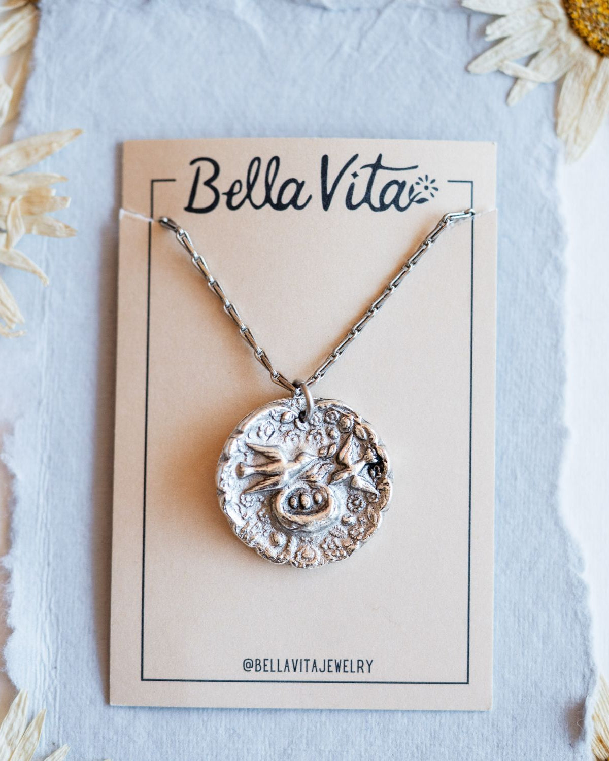 Silver cast mama bird heirloom pendant shown with Bella Vita artisan jewelry packaging