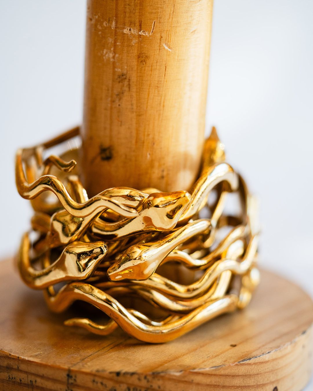 Detailed view of shiny brass serpent cuff with intricately twisted metal on display