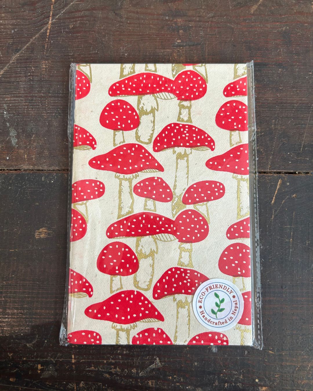 Eco-conscious blank journal with whimsical red mushroom pattern on white background.