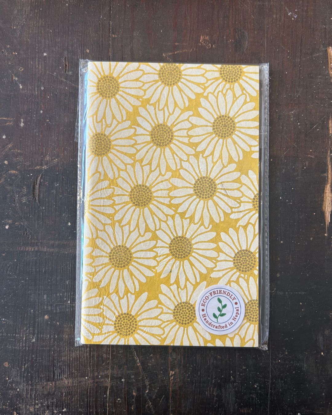 Sustainable unlined journal featuring cheerful yellow daisy pattern on cover.