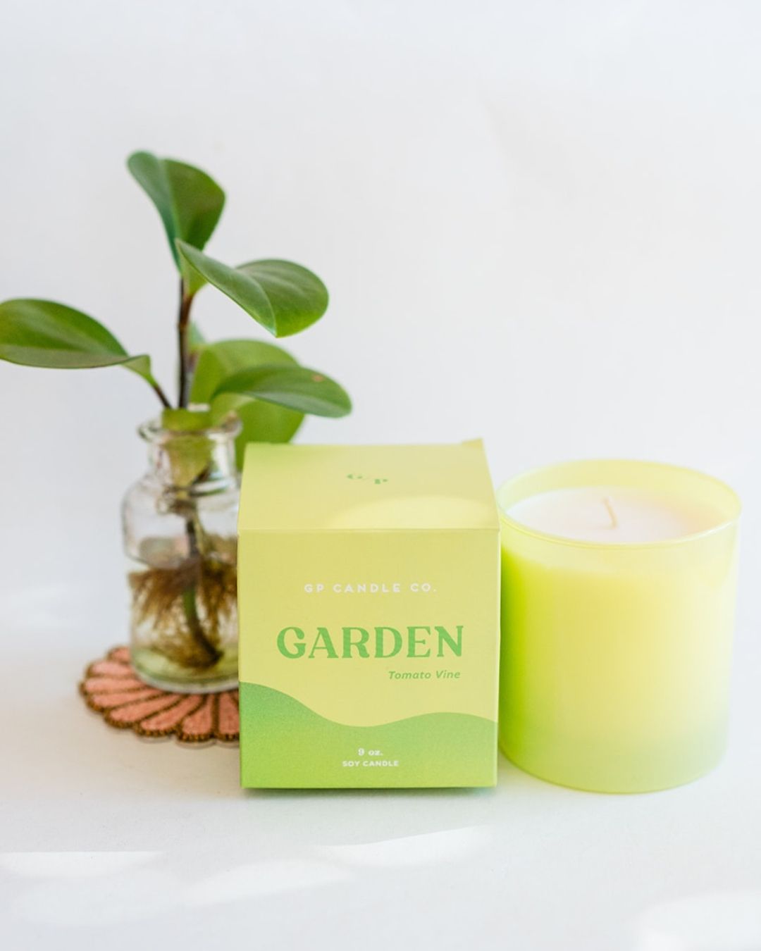 Garden 9oz Hue Candle in lime green with Tomato Vine scent, presented with packaging and small plant decoration.