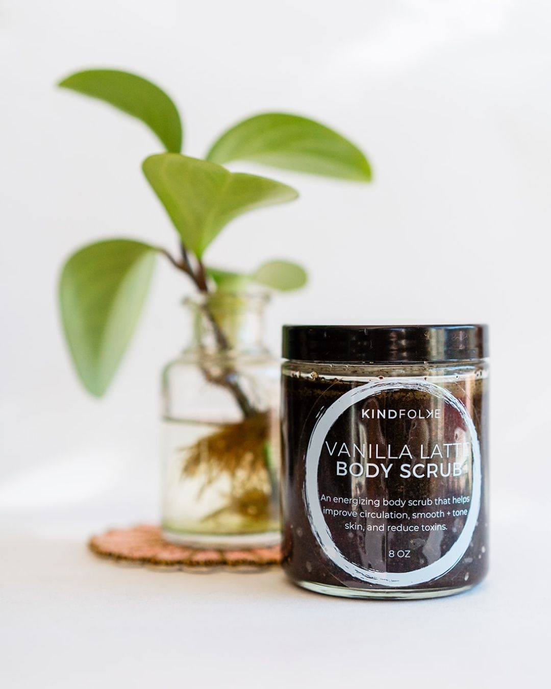 Vanilla Latte coffee body scrub displayed with water plant - tones and detoxifies