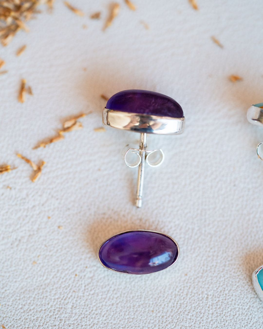 Purple amethyst oval studs with sterling silver bezels displayed on white background