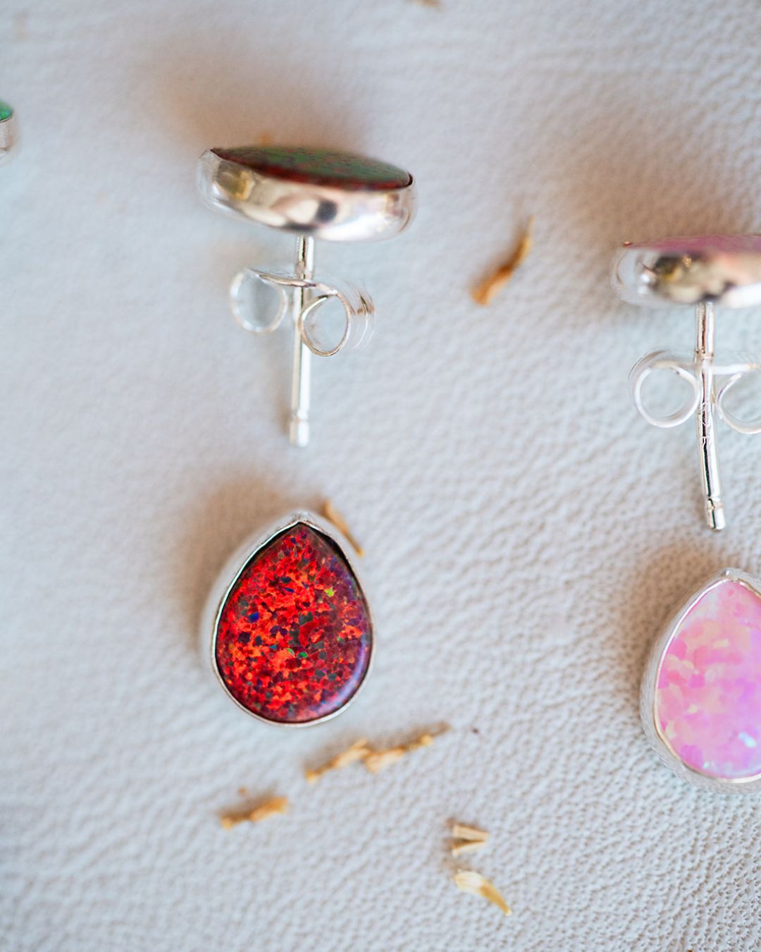 Red Fall and pink Spring sterling silver opal studs shown on white surface