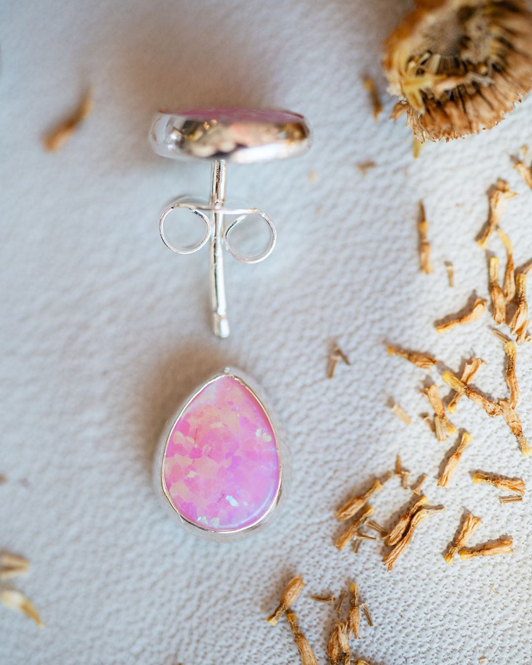 Sterling silver pink opal stud earrings for Spring season on textured background