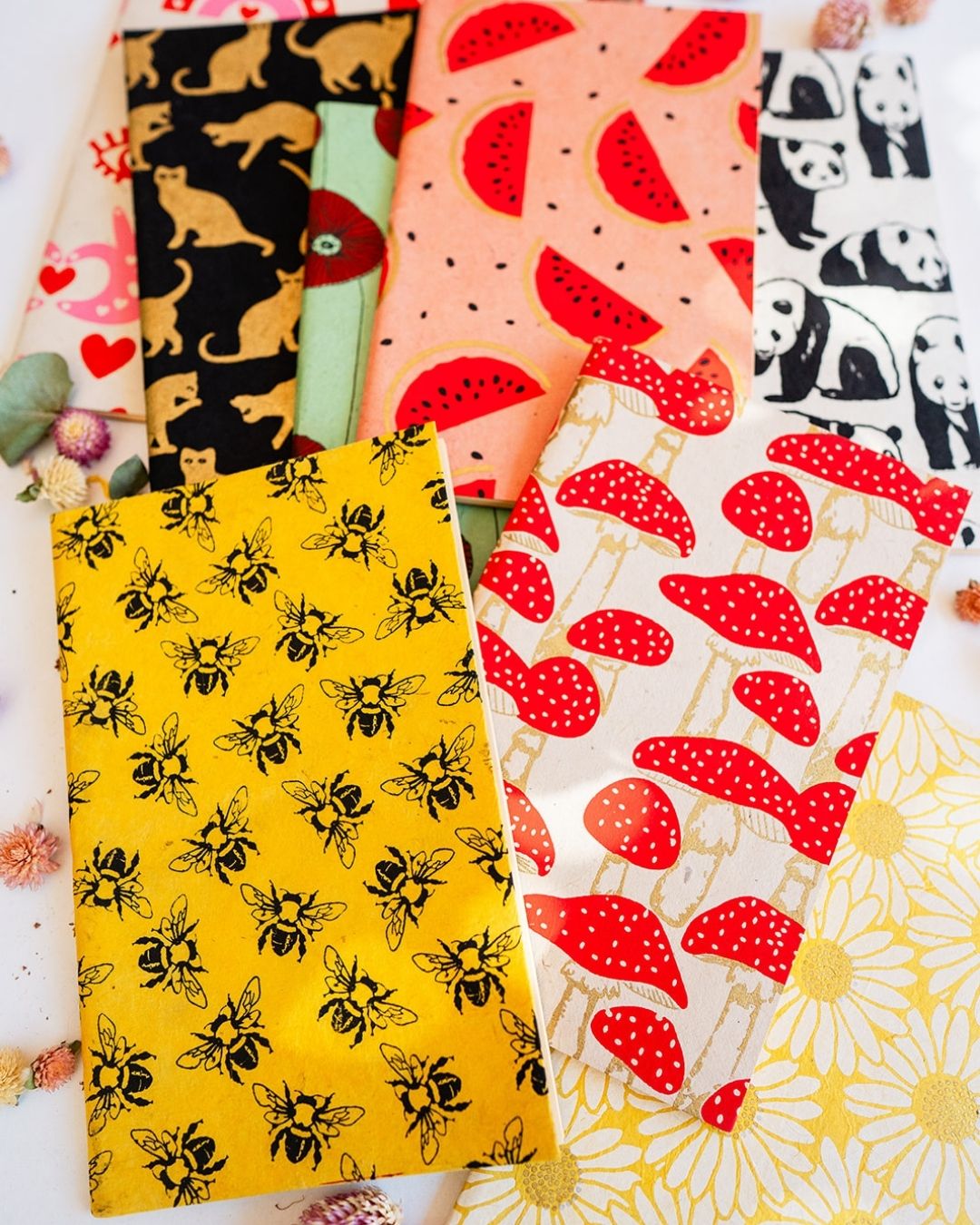 Collection of eco-friendly blank journals in various colorful patterns - sustainable handcrafted notebooks with unlined pages.