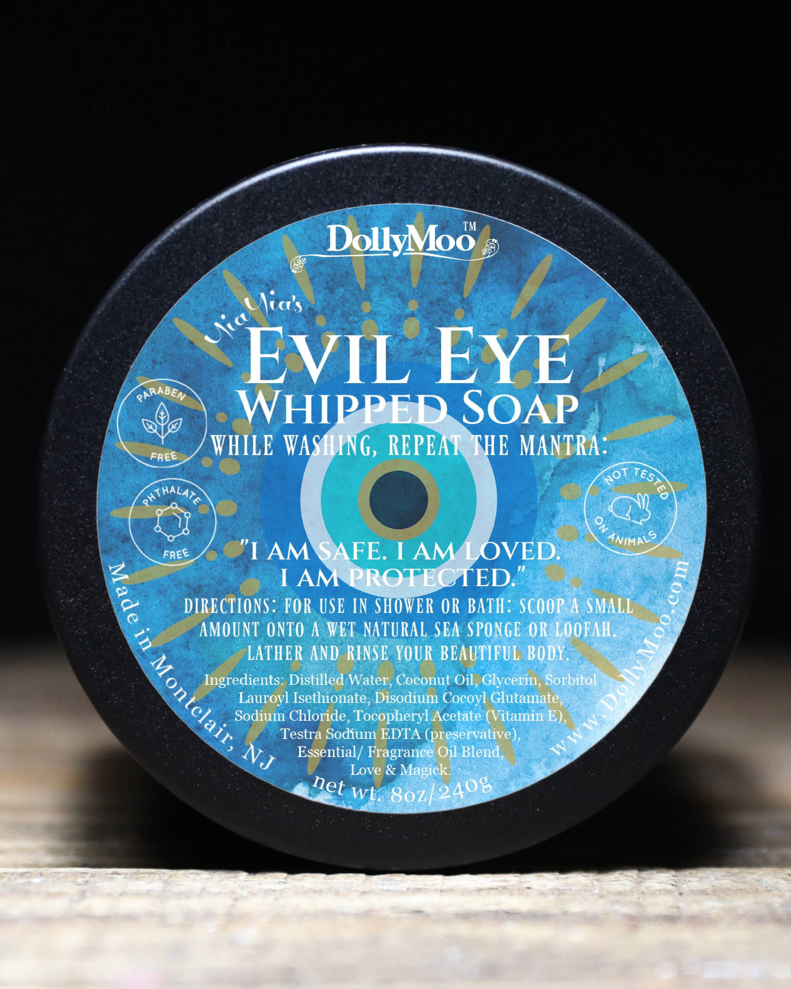 DollyMoo Evil Eye Whipped Soap in circular container featuring traditional blue Evil Eye protection symbol with affirmation 'I am safe, I am loved, I am protected' and coconut oil-based cleansing formula.
