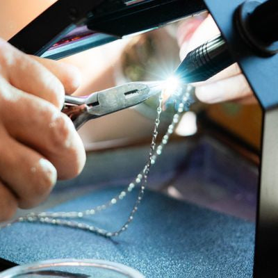 Close-up of Brandy welding a permanent jewelry chain at Bella Vita, showcasing the precision and craftsmanship involved in creating seamless, clasp-free bracelets and anklets.
