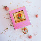 Song of India Honeysuckle natural solid fragrance in pink decorative box with brass container featuring orange sunflower design, showing opened container below.