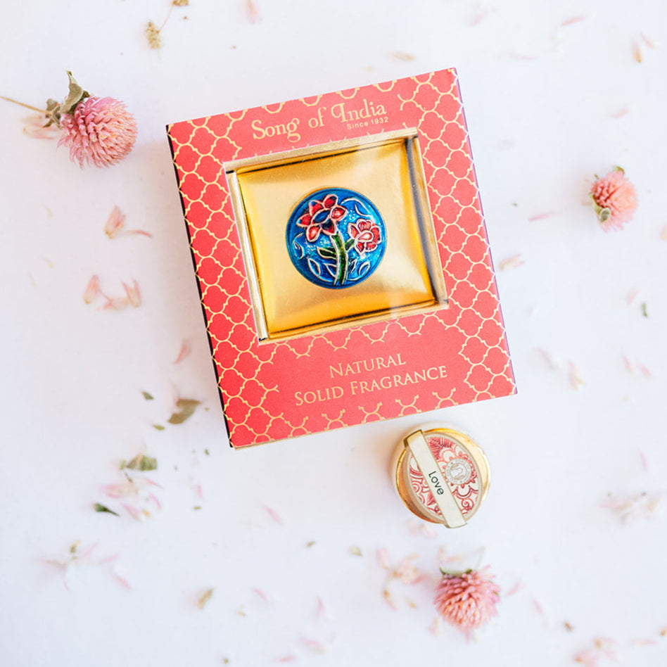Song of India Love natural solid fragrance in red box with gold lattice pattern, showcasing blue background brass container with vibrant floral design.