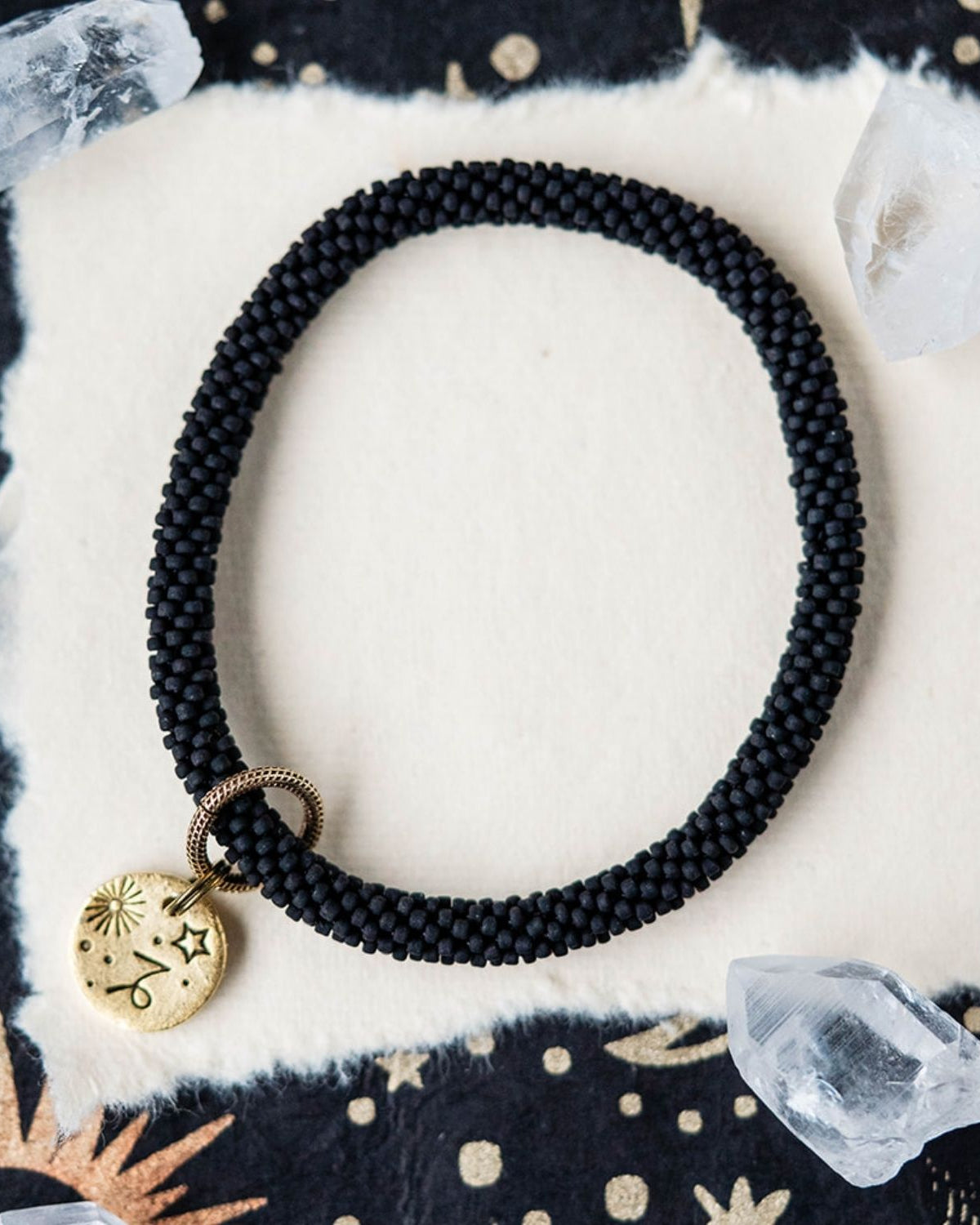 Black beaded bracelet with gold Capricorn zodiac pendant styled with clear crystals and stars