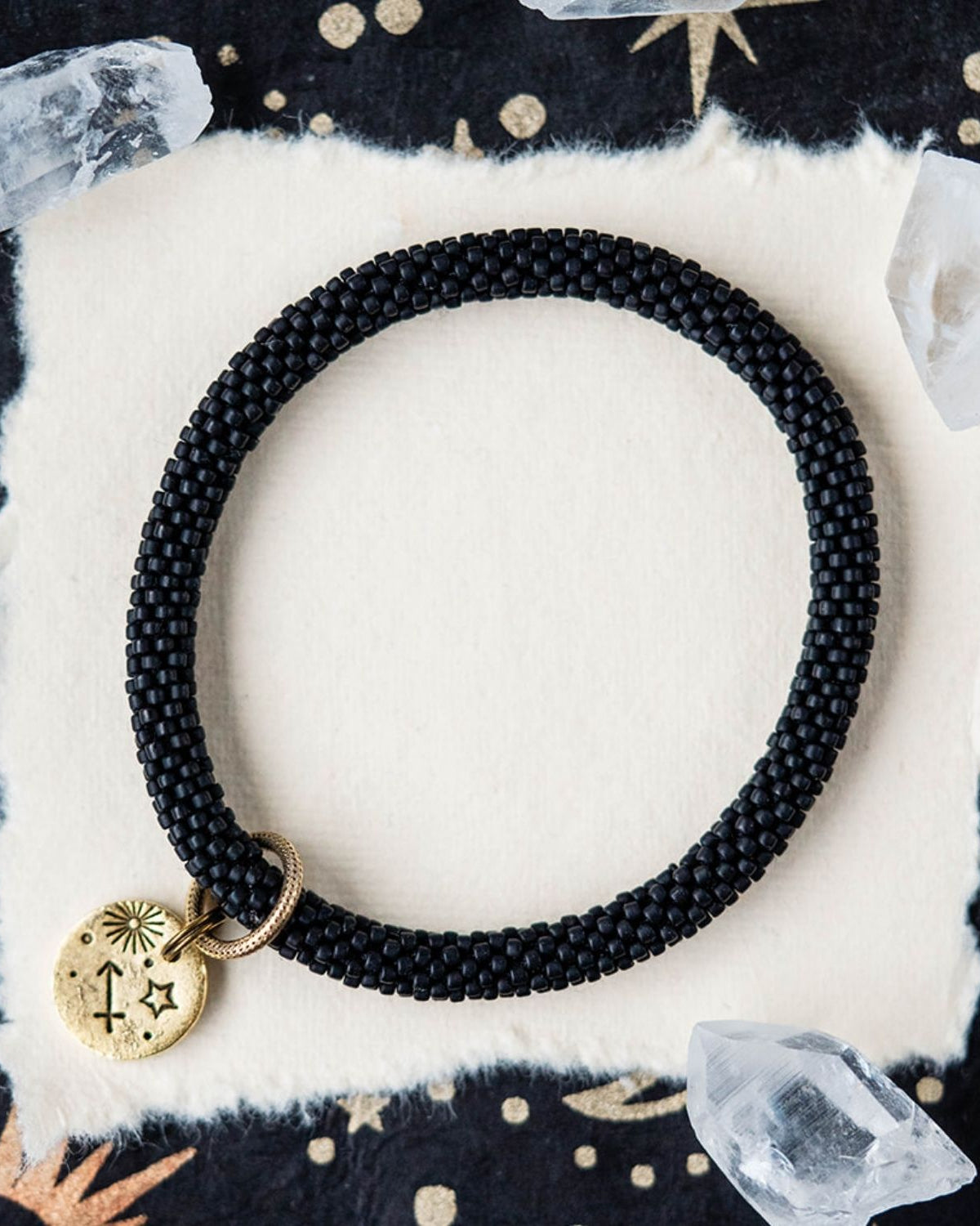 Black beaded bracelet with gold Sagittarius zodiac pendant styled with crystals and stars