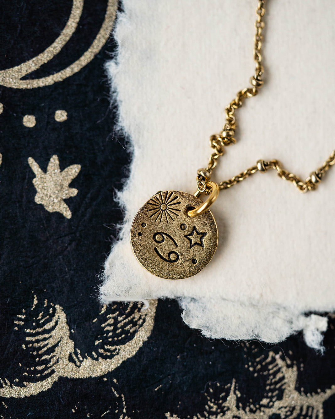 Gold Cancer zodiac pendant necklace with crab constellation and celestial symbols on chain