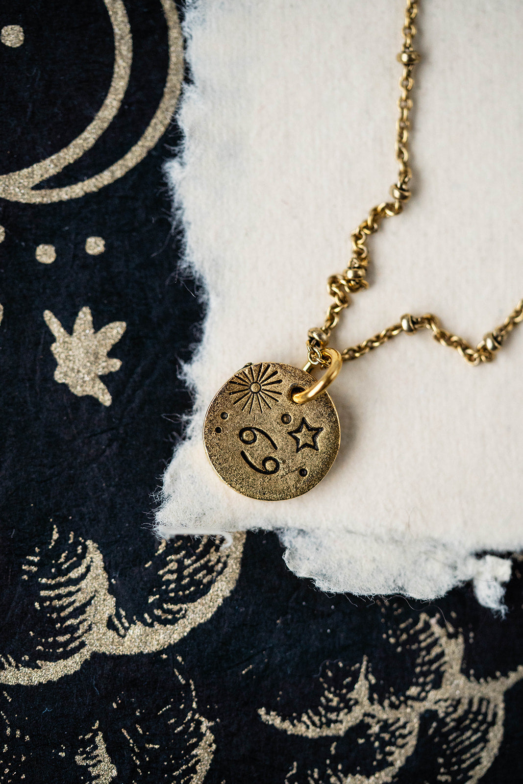 Gold Cancer zodiac pendant necklace with crab constellation and celestial symbols on chain