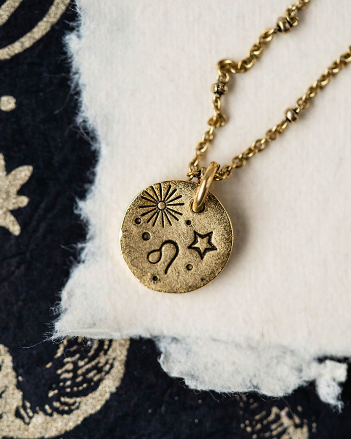 Gold Leo zodiac pendant necklace with lion symbol and celestial engravings on chain