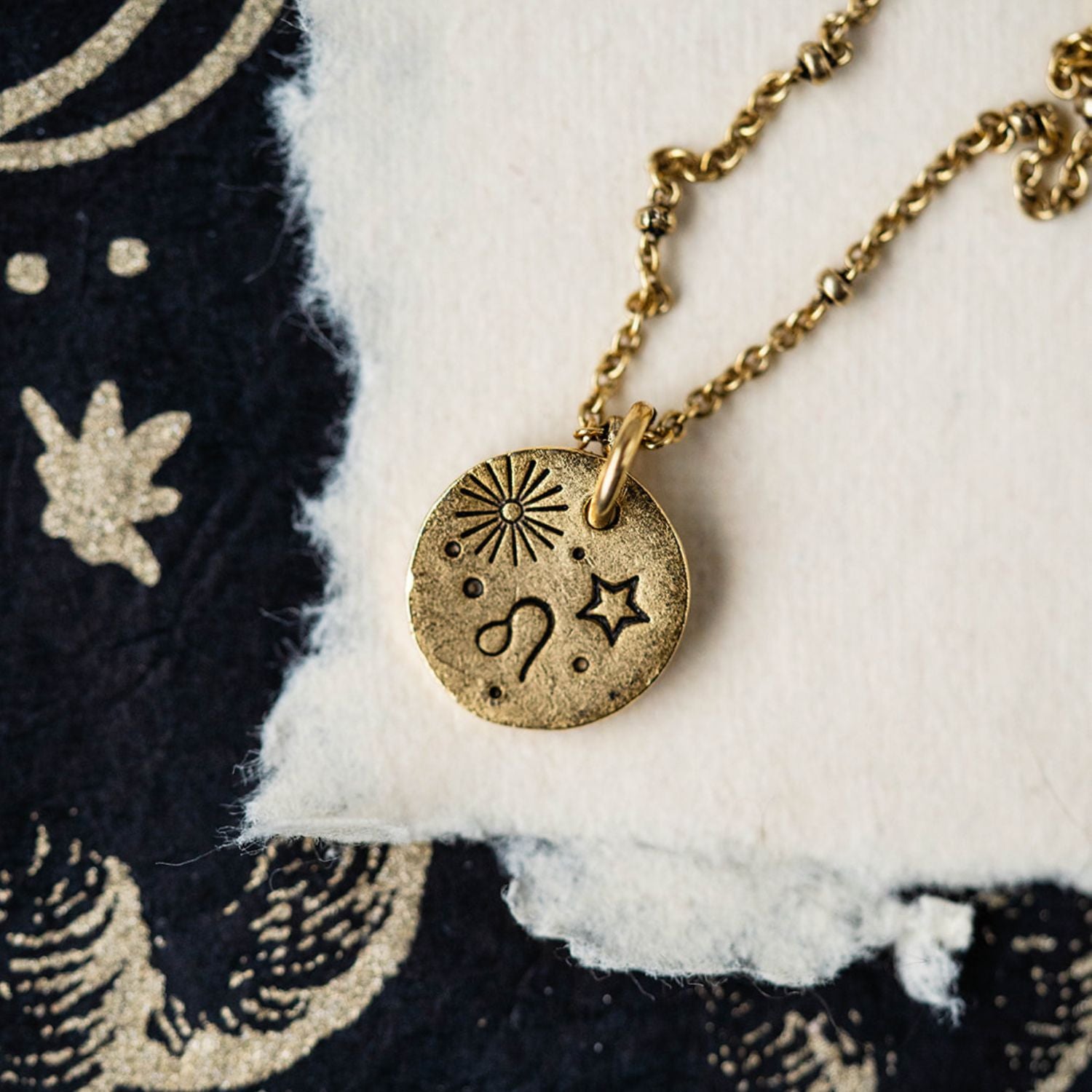 Gold Leo zodiac pendant necklace with lion symbol and celestial engravings on chain