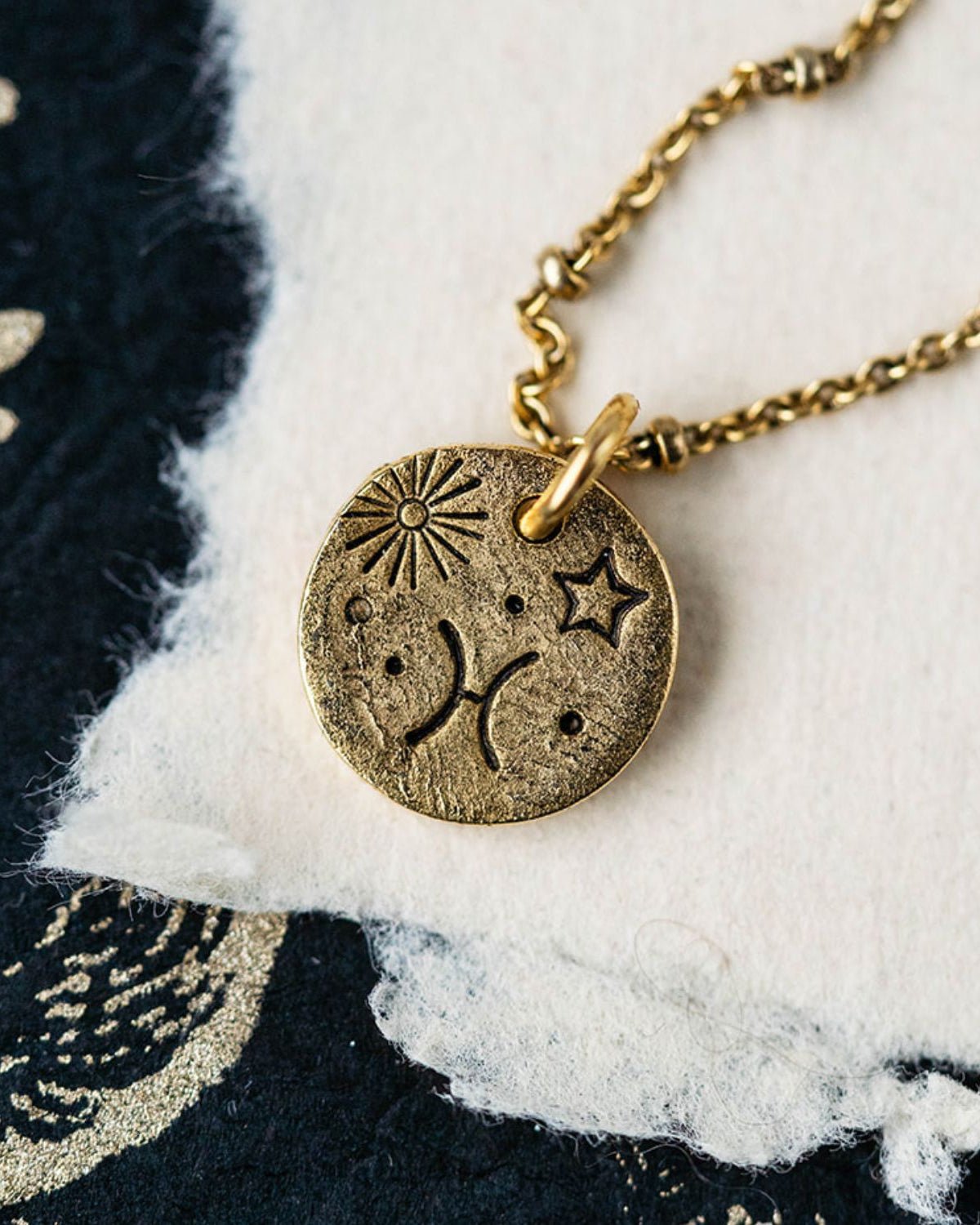 Gold Pisces zodiac pendant necklace with fish symbols and celestial engravings on chain