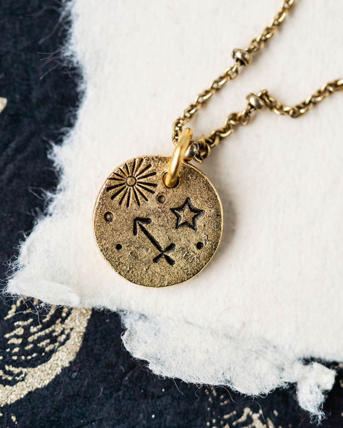 Gold Sagittarius zodiac pendant necklace with archer bow symbols and celestial engravings on chain