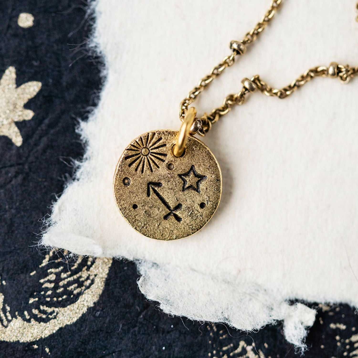 Gold Sagittarius zodiac pendant necklace with archer bow symbols and celestial engravings on chain