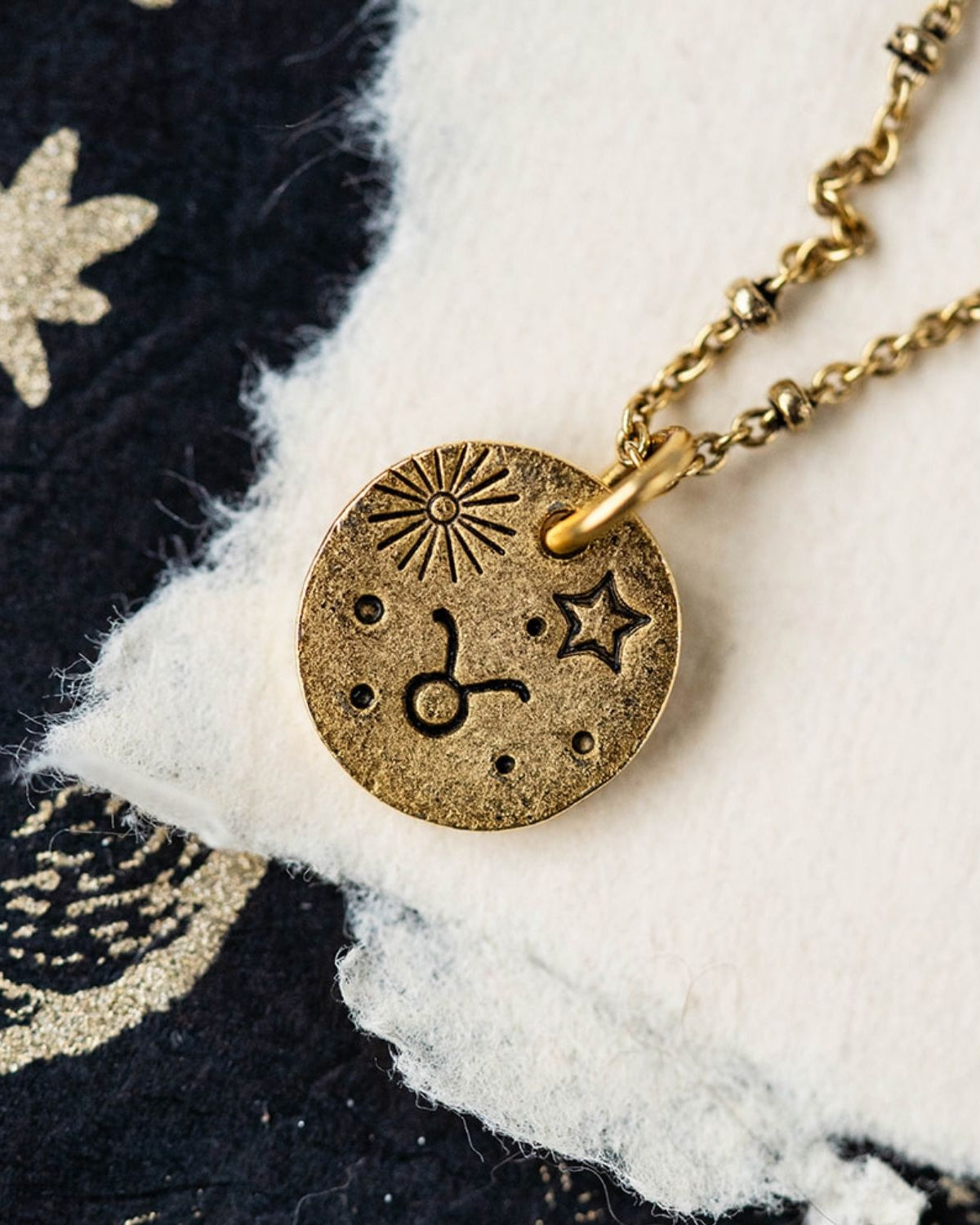 Gold Taurus zodiac pendant necklace with bull symbols and celestial engravings on chain