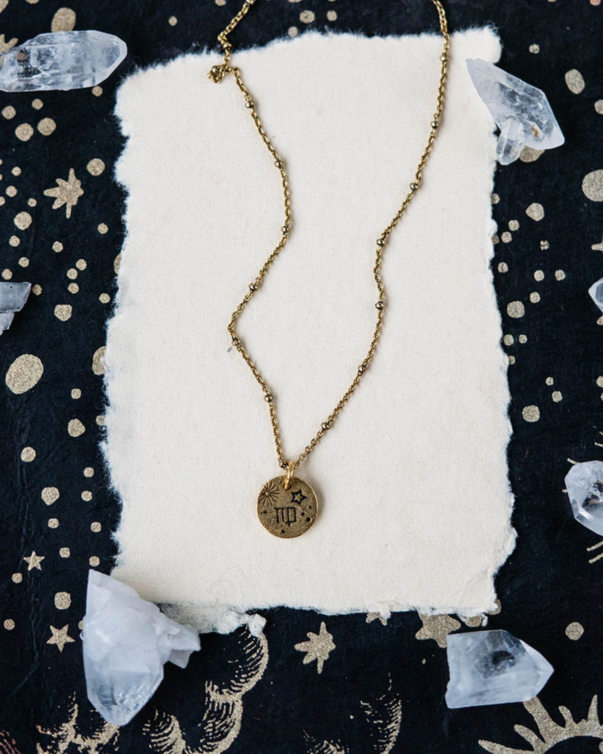 Virgo constellation charm necklace featuring gold disc with engraved harvest and star symbols