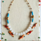 Necklace with fish-shaped beads on a textured white background