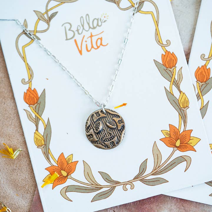 Handcrafted Art Nouveau bronze flower necklace displayed on a decorative Bella Vita card with a natural floral motif