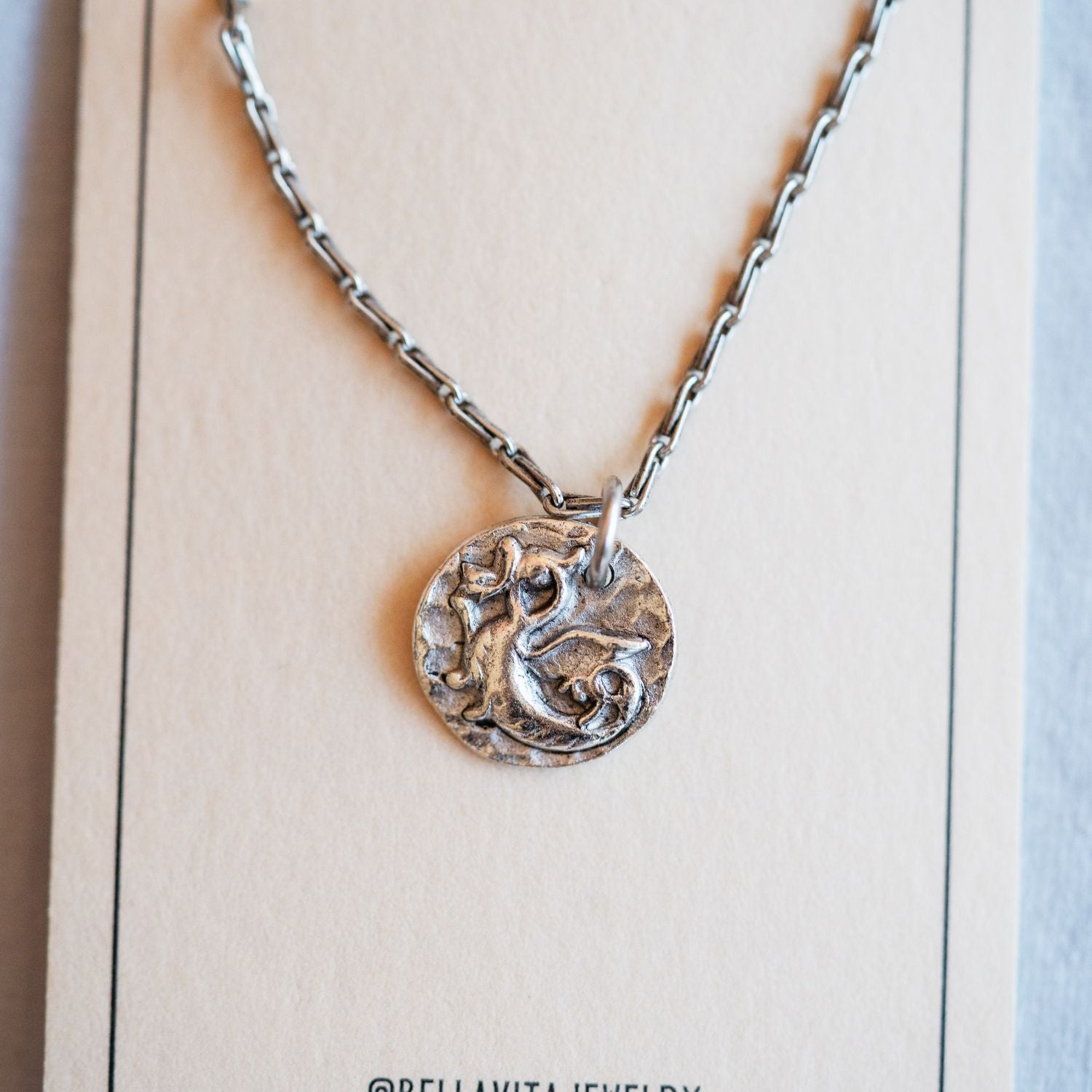 Silver cast dragon heirloom pendant displayed on Bella Vita branded artisan jewelry card
