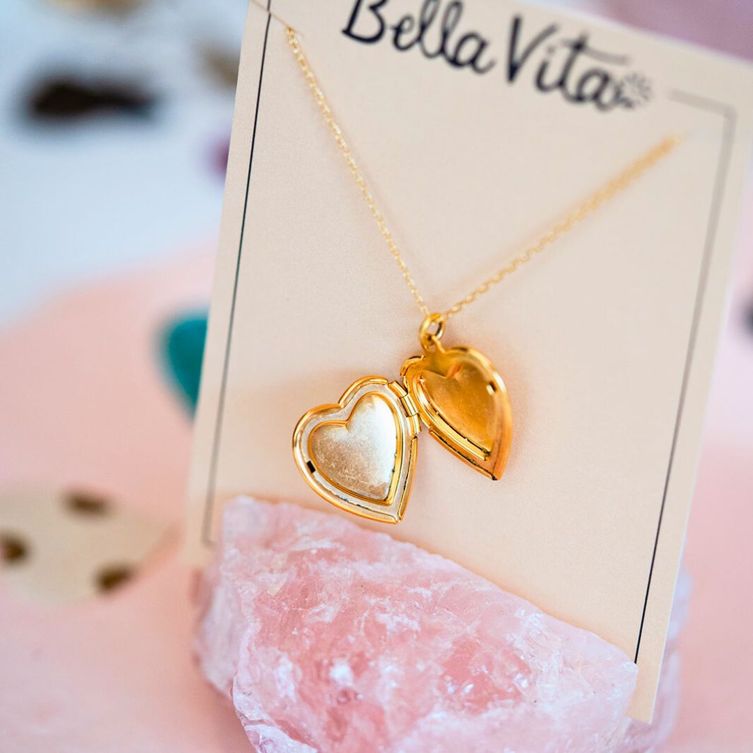 Bella Vita Jewelry gold heart locket necklace on display card with rose quartz crystal prop