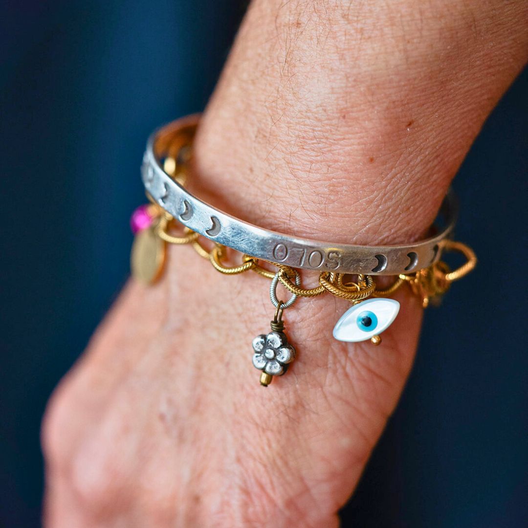 Bella Vita Jewelry bracelet featuring silver moon phases design with gold chain accent, evil eye charm and flower detail