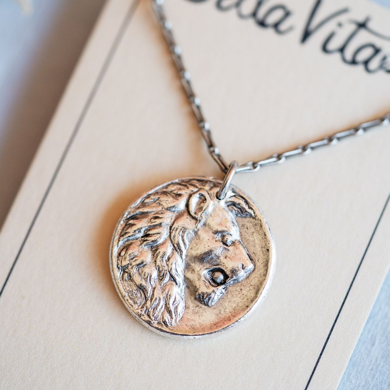 Artisan silver lion pendant necklace featuring vintage button casting by Bella Vita Jewelry
