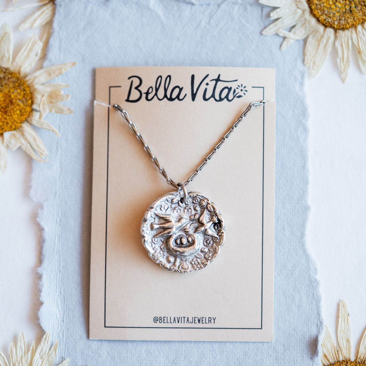 Silver cast mama bird heirloom pendant shown with Bella Vita artisan jewelry packaging