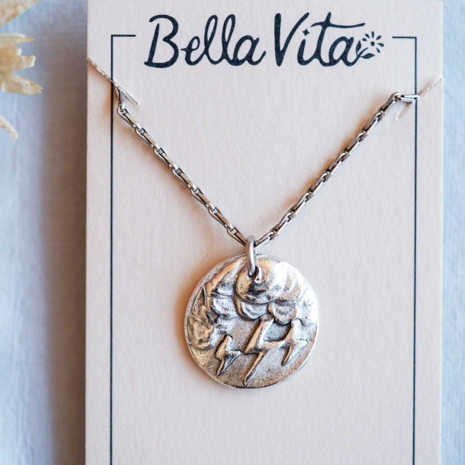 Silver cast storm cloud heirloom pendant shown with Bella Vita artisan jewelry packaging
