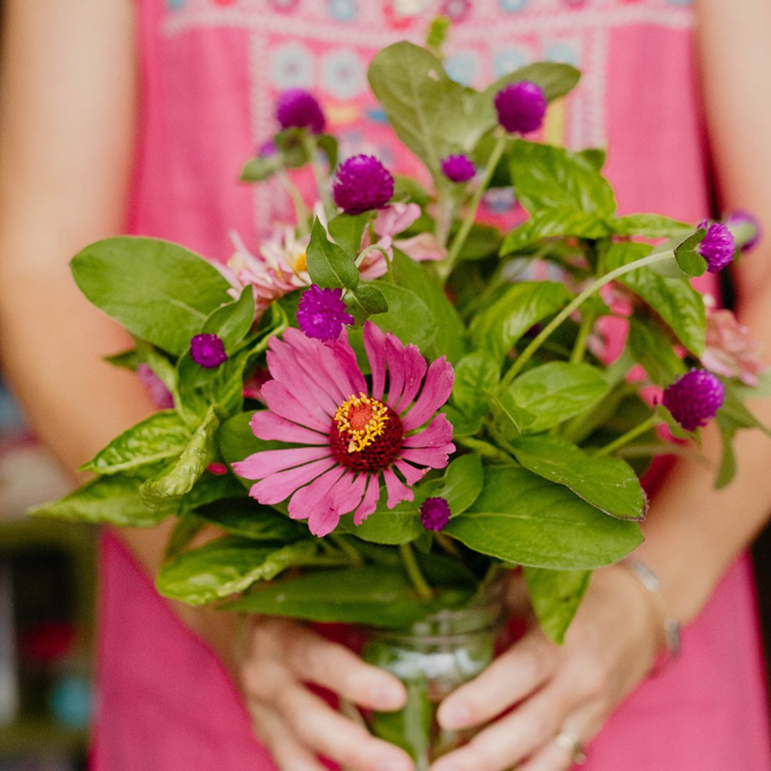 Fresh mixed bouquet of zinnias, gomphrena, and basil in a mason jar, part of the Bella Vita Summer Subscription.