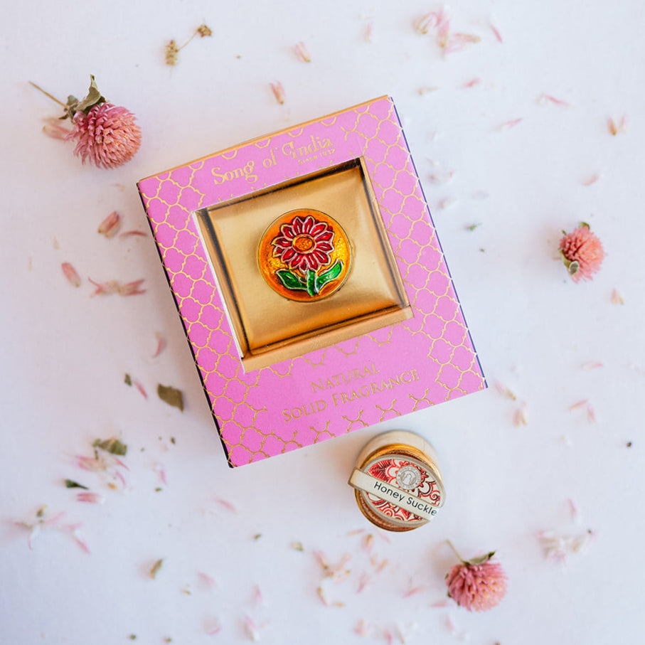 Song of India Honeysuckle natural solid fragrance in pink decorative box with brass container featuring orange sunflower design, showing opened container below.