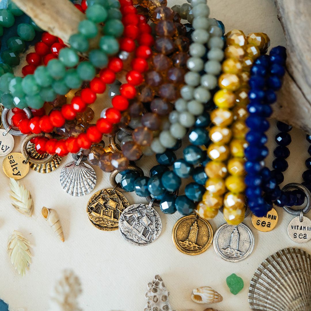 Colorful beaded Yacht Rock bracelets featuring lighthouse, ship, and shell charms in gold and silver finishes