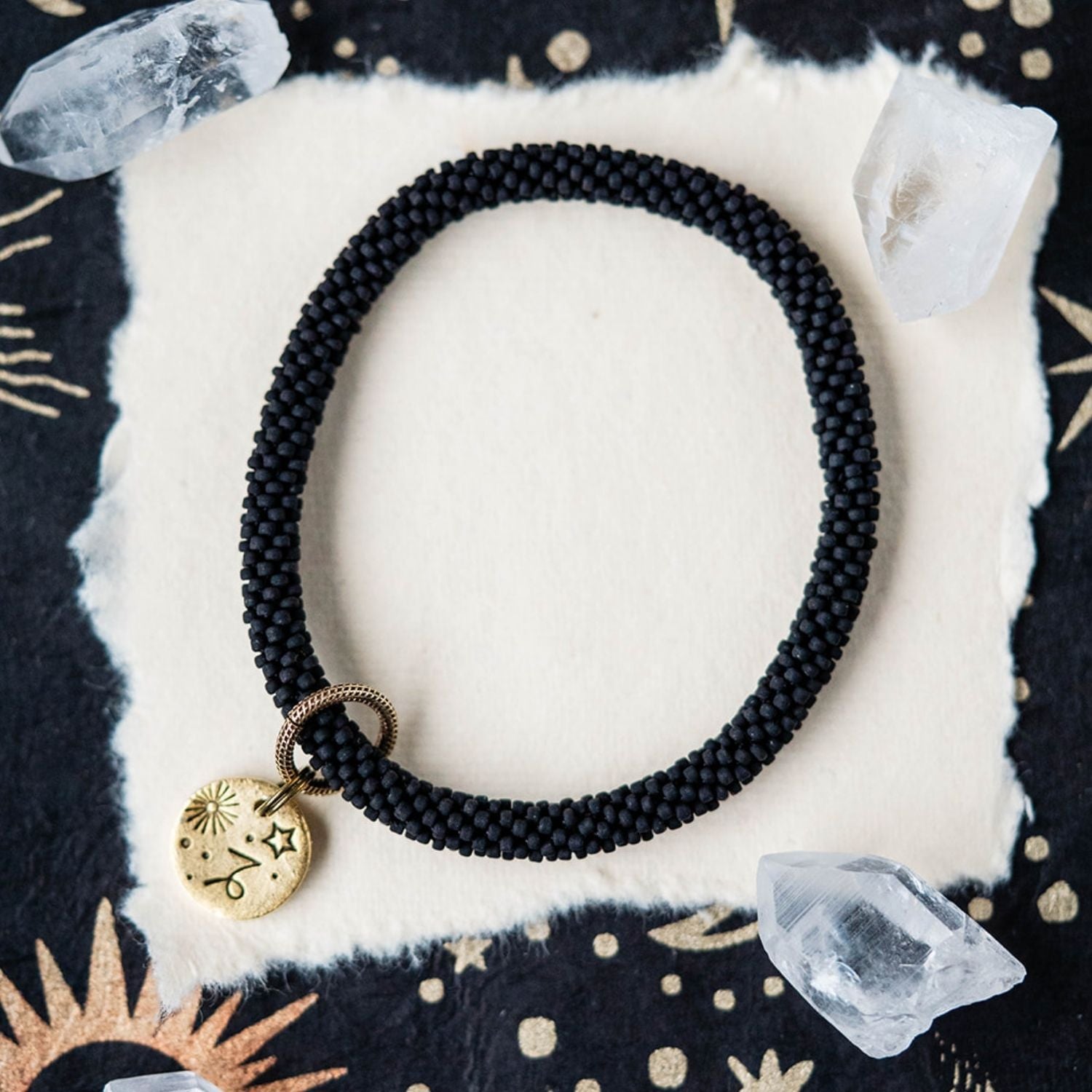 Black beaded bracelet with gold Capricorn zodiac pendant styled with clear crystals and stars