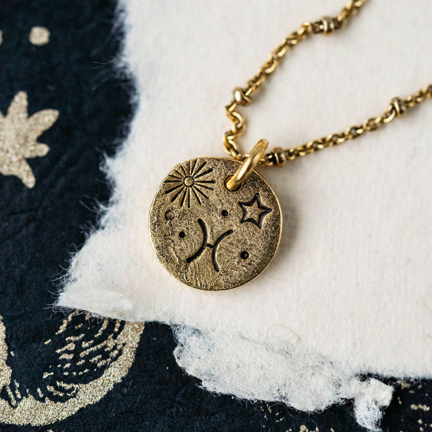 Gold Pisces zodiac pendant necklace with fish symbols and celestial engravings on chain