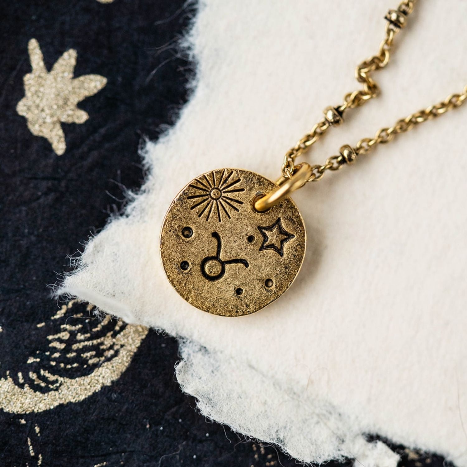 Gold Taurus zodiac pendant necklace with bull symbols and celestial engravings on chain